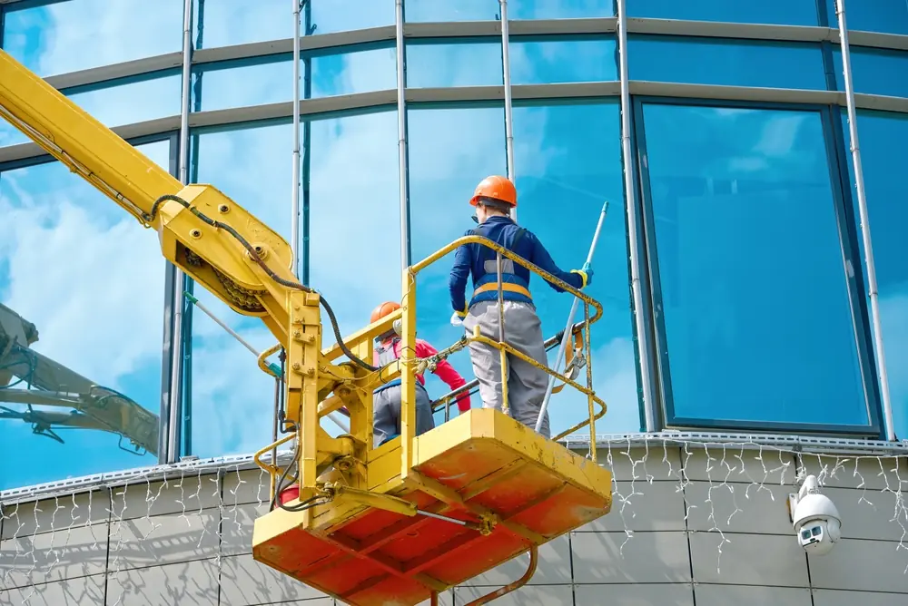 Maintenance crew in a yellow lift basket representing cherry picker hire services Maintenance crew in a yellow lift basket representing cherry picker hire services